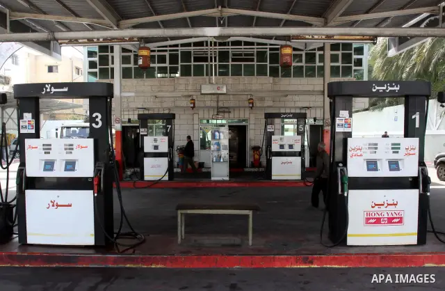 Palestinians fill containers with fuel from a petrol station in the Gaza City on 21 March 2012. Reports state that residents in the Gaza Strip flocked to petrol stations hoping to get a share of the remaining fuel, sayin...