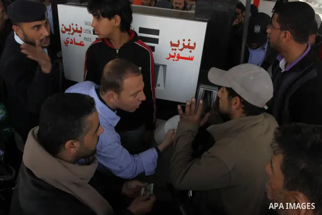 Palestinians fill containers with fuel from a petrol station in the Gaza City on 21 March 2012. Reports state that residents in the Gaza Strip flocked to petrol stations hoping to get a share of the remaining fuel, sayin...