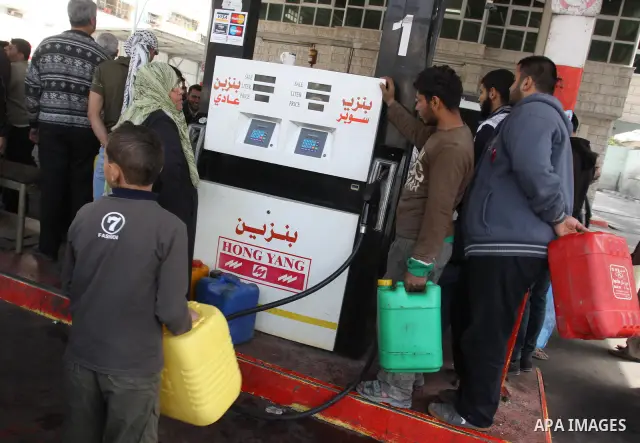 Palestinians fill containers with fuel from a petrol station in the Gaza City on 21 March 2012. Reports state that residents in the Gaza Strip flocked to petrol stations hoping to get a share of the remaining fuel, sayin...
