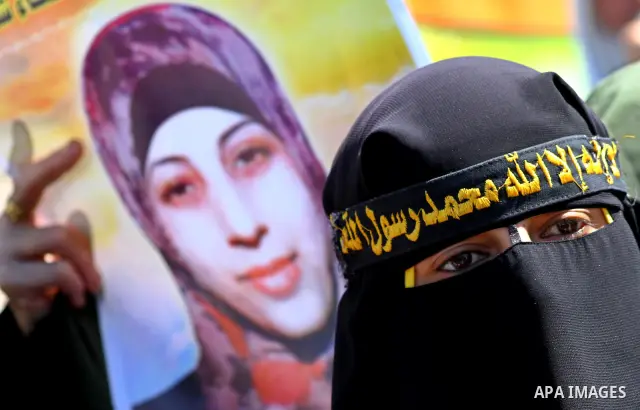 Palestinian women hold portraits of jailed compatriot Hana Shalabi, a female Palestinian prisoner jailed in Israel who has been on hunger strike for 37 days, outside the Red Cross building in Gaza City on Mar. 22, 2012....