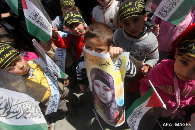 Palestinian children hold portraits of jailed compatriot Hana Shalabi, a female Palestinian prisoner jailed in Israel who has been on hunger strike for 37 days, outside the Red Cross building in Gaza City on Mar. 22, 201...