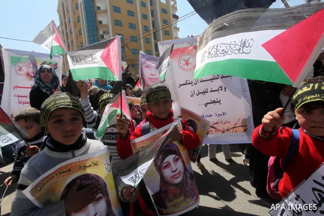 Palestinian children hold portraits of jailed compatriot Hana Shalabi, a female Palestinian prisoner jailed in Israel who has been on hunger strike for 37 days, outside the Red Cross building in Gaza City on Mar. 22, 201...