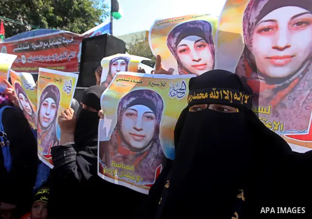 Palestinian women hold portraits of jailed compatriot Hana Shalabi, a female Palestinian prisoner jailed in Israel who has been on hunger strike for 37 days, outside the Red Cross building in Gaza City on Mar. 22, 2012....
