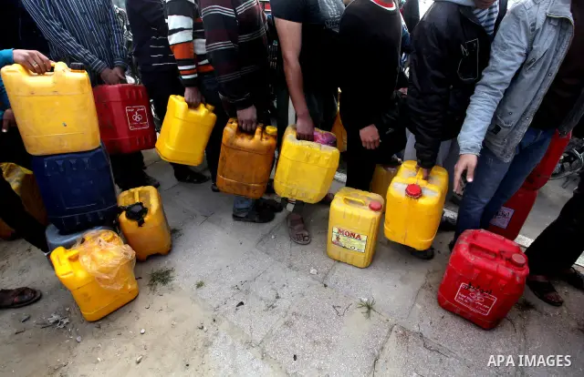 Palestinians wait to fill containers with fuel at a petrol station in Bit Lahia in the northern Gaza Strip March 22, 2012. Palestinians in the Gaza Strip are suffering a crisis of dry petrol pumps and frequent blackouts...