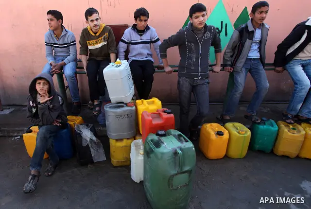 Palestinians wait to fill containers with fuel at a petrol station in Bit Lahia in the northern Gaza Strip March 22, 2012. Palestinians in the Gaza Strip are suffering a crisis of dry petrol pumps and frequent blackouts...