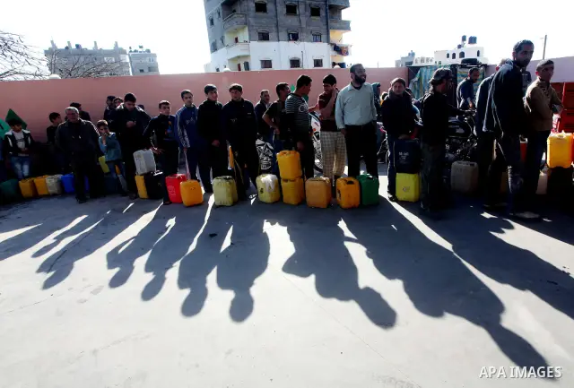 Palestinians wait to fill containers with fuel at a petrol station in Bit Lahia in the northern Gaza Strip March 22, 2012. Palestinians in the Gaza Strip are suffering a crisis of dry petrol pumps and frequent blackouts...