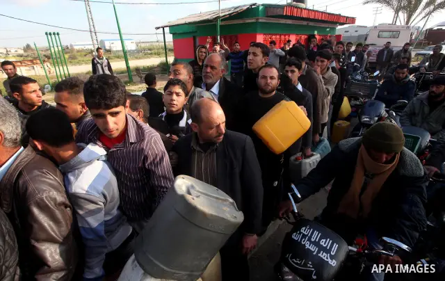 Palestinians wait to fill containers with fuel at a petrol station in Bit Lahia in the northern Gaza Strip March 22, 2012. Palestinians in the Gaza Strip are suffering a crisis of dry petrol pumps and frequent blackouts...