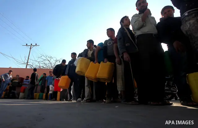 Palestinians wait to fill containers with fuel at a petrol station in Bit Lahia in the northern Gaza Strip March 22, 2012. Palestinians in the Gaza Strip are suffering a crisis of dry petrol pumps and frequent blackouts...
