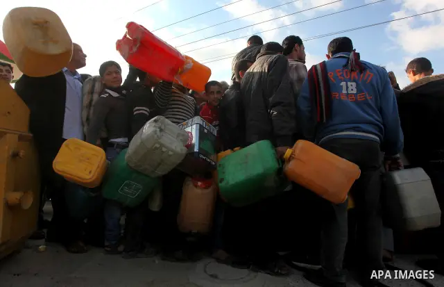Palestinians wait to fill containers with fuel at a petrol station in Bit Lahia in the northern Gaza Strip March 22, 2012. Palestinians in the Gaza Strip are suffering a crisis of dry petrol pumps and frequent blackouts...