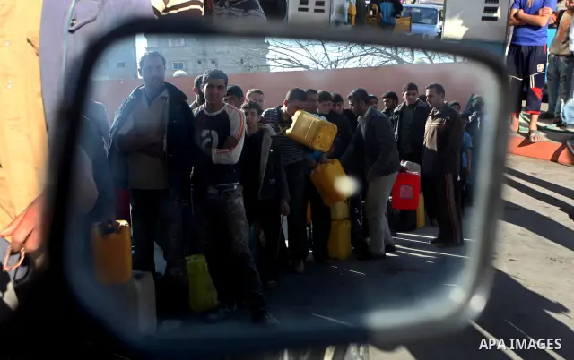 Palestinians wait to fill containers with fuel at a petrol station in Bit Lahia in the northern Gaza Strip March 22, 2012. Palestinians in the Gaza Strip are suffering a crisis of dry petrol pumps and frequent blackouts...