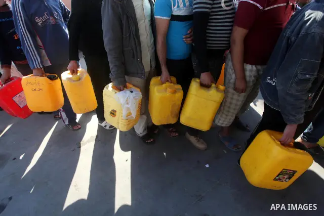 Palestinians wait to fill containers with fuel at a petrol station in Bit Lahia in the northern Gaza Strip March 22, 2012. Palestinians in the Gaza Strip are suffering a crisis of dry petrol pumps and frequent blackouts...