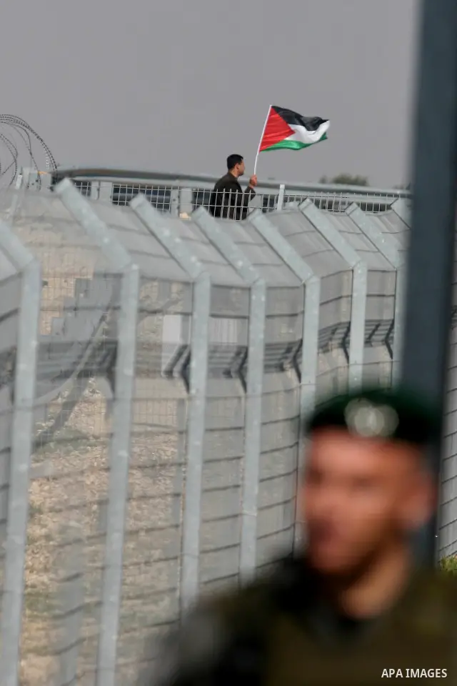 Israeli soldiers stand guard in front of Palestinian protesters demonstrating against the relocation of an Israeli road gate in the village of Beit Iksa in the occupied West Bank between Ramallah and Jerusalem on March 2...