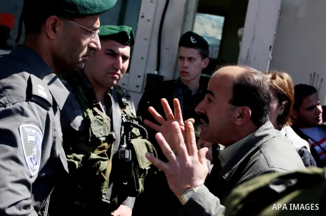 Israeli soldiers stand guard in front of Palestinian protesters demonstrating against the relocation of an Israeli road gate in the village of Beit Iksa in the occupied West Bank between Ramallah and Jerusalem on March 2...