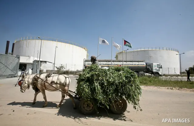 A Palestinian man drives a donkey cart as a fuel tanker arrives at a power plant in Al-Nusirat, central Gaza Strip, 23 March 2012. The tanker crossed into Gaza at the Israeli Kerem Shalom border crossing after Egypt and...