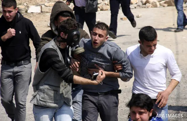 Palestinians carry an injured man during a protest in the village of Kufr Qaddum near the Israeli settlement of Kdumim, in the northern West Bank, Friday, March 23, 2012. Photo by Wagdi Eshtayah