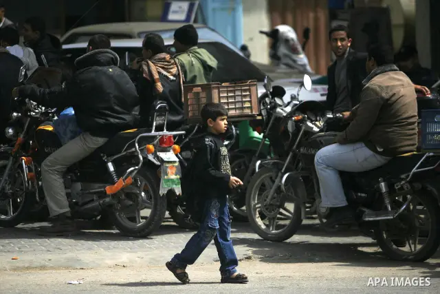 Palestinians wait to fill containers with fuel at a petrol station in Rafah on the southern Gaza Strip March 24, 2012. Palestinians in the Gaza Strip are suffering a crisis of dry petrol pumps and frequent blackouts trig...