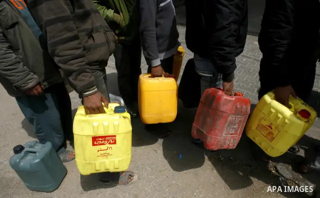 Palestinians wait to fill containers with fuel at a petrol station in Rafah on the southern Gaza Strip March 24, 2012. Palestinians in the Gaza Strip are suffering a crisis of dry petrol pumps and frequent blackouts trig...