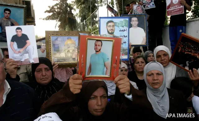Palestinians hold portraits of relatives detained in Israeli prisons as they protest to demand for their release during a demonstration in support of Hanaa al-Shalabi outside Damascus gate, in the old city of Jerusalem,...