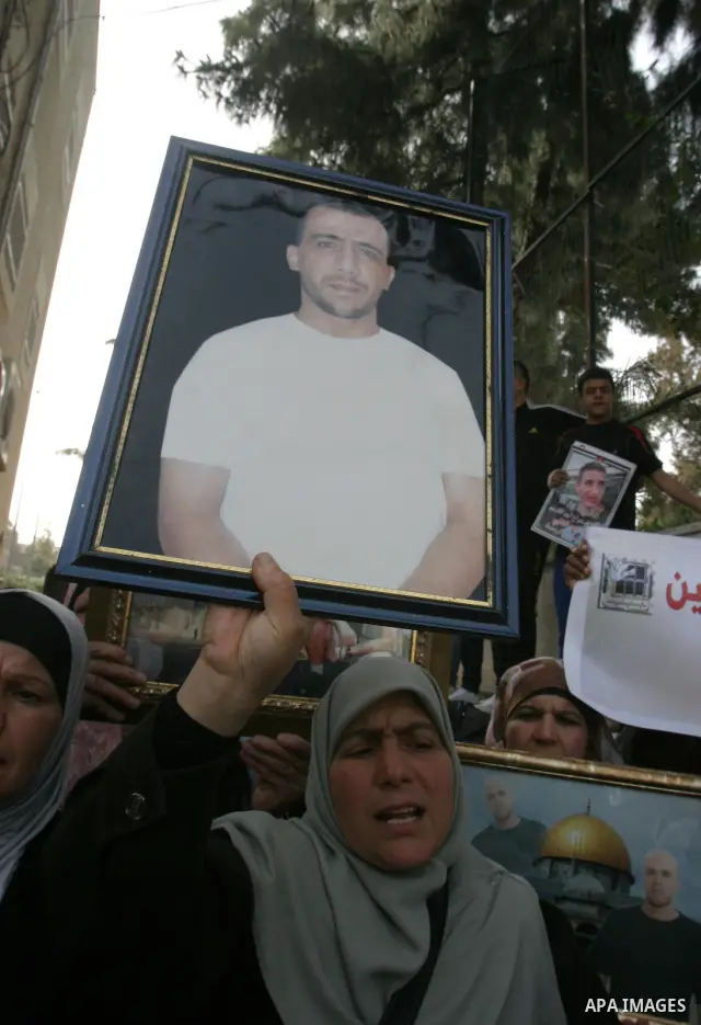Palestinians hold portraits of relatives detained in Israeli prisons as they protest to demand for their release during a demonstration in support of Hanaa al-Shalabi outside Damascus gate, in the old city of Jerusalem,...