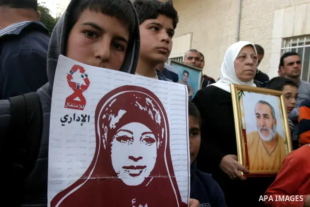 Palestinians hold portraits of relatives detained in Israeli prisons as they protest to demand for their release during a demonstration in support of Hanaa al-Shalabi outside Damascus gate, in the old city of Jerusalem,...