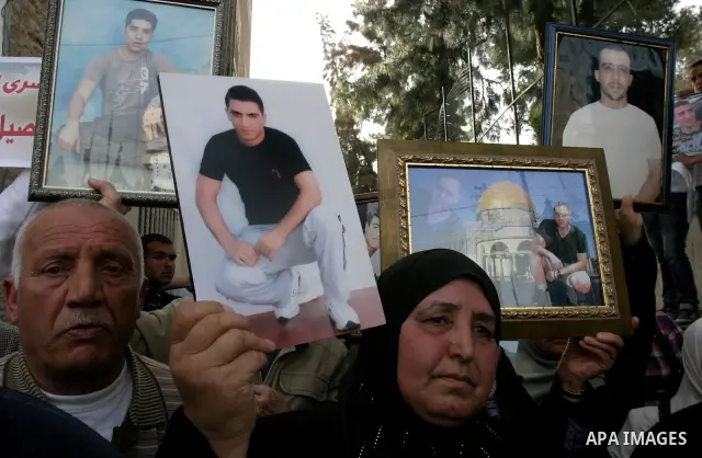Palestinians hold portraits of relatives detained in Israeli prisons as they protest to demand for their release during a demonstration in support of Hanaa al-Shalabi outside Damascus gate, in the old city of Jerusalem,...