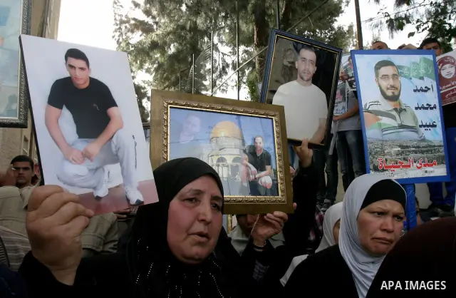 Palestinians hold portraits of relatives detained in Israeli prisons as they protest to demand for their release during a demonstration in support of Hanaa al-Shalabi outside Damascus gate, in the old city of Jerusalem,...