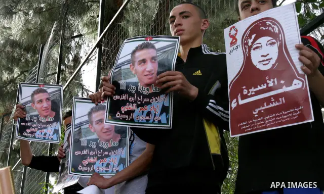 Palestinians hold portraits of relatives detained in Israeli prisons as they protest to demand for their release during a demonstration in support of Hanaa al-Shalabi outside Damascus gate, in the old city of Jerusalem,...