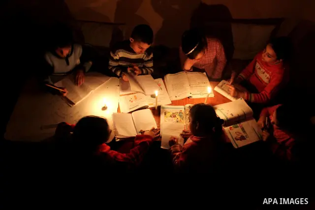 Palestinian children use a candle light during a power cut in Jabaliya refugee camp in the northern Gaza Strip 24 March 2012. The only remaining power plant in the Gaza Strip halted working because it run out of fuel, ca...