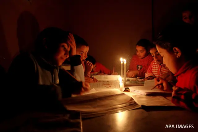 Palestinian children use a candle light during a power cut in Jabaliya refugee camp in the northern Gaza Strip 24 March 2012. The only remaining power plant in the Gaza Strip halted working because it run out of fuel, ca...