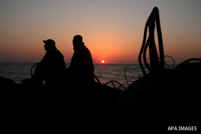Palestinians enjoy their times during the sunset in Gaza fishing seaport, on March 23, 2012. Photo by Emad Nassar