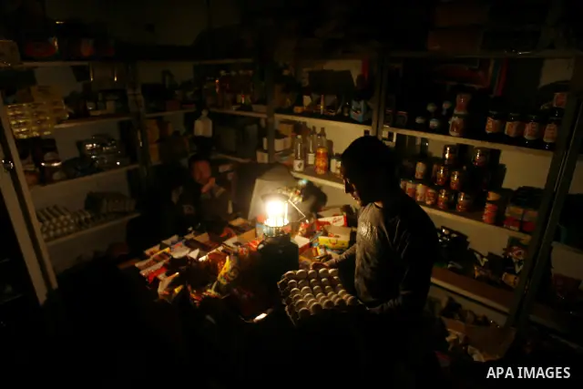 A Palestinian man sits in his shop during a blackout in Rafah on the southern Gaza Strip on, 26 March 2012. The only remaining power plant in the Gaza Strip halted working because it run out of fuel, causing a blackout,...