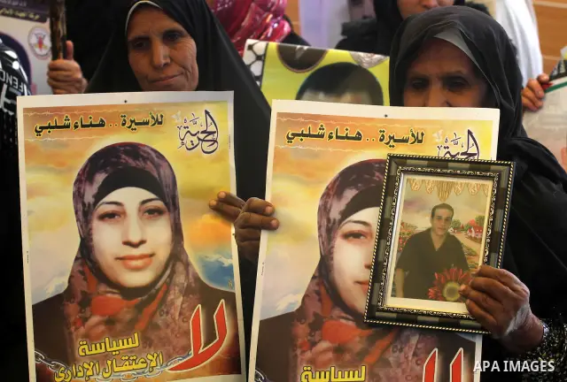 Palestinian women hold portrait of jailed compatriot Hana Shalabi, a female Palestinian prisoner jailed in Israel, outside the Red Cross building in Gaza City on March 26, 2012. Photo by Mohammed Asad