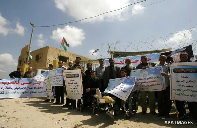 Palestinian demonstrators hold posters during a protest in the Rafah border crossing with Egypt on March 26, 2012, demanding Egypt provide the Gaza Strip with electricity and fuel. The Palestinian energy authority in Gaz...