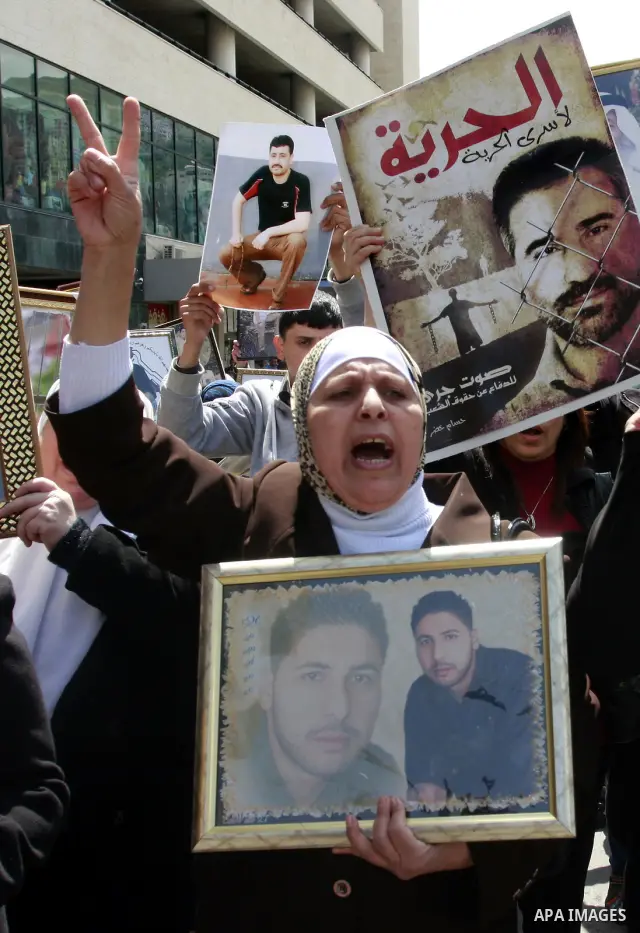 Palestinians hold pictures of prisoners jailed in Israel during a demonstration calling for their release, in the West Bank city of Nablus, Monday, March 26, 2012. Photo by Wagdi Eshtayah