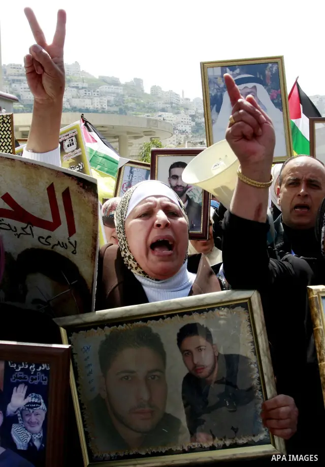 Palestinians hold pictures of prisoners jailed in Israel during a demonstration calling for their release, in the West Bank city of Nablus, Monday, March 26, 2012. Photo by Wagdi Eshtayah