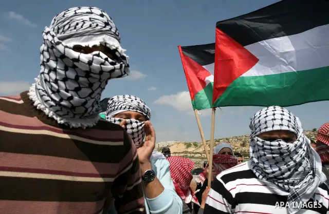 Masked Palestinian demonstrators call for the release of prisoners during a protest outside the Ofer military prison, near the West Bank city of Ramallah Monday, March 26, 2012. Clashes erupted during a demonstration cal...