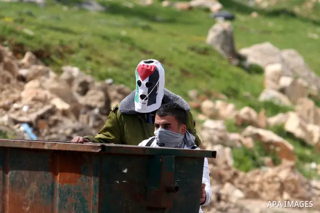 Palestinians clash with Israeli troops, not seen, during a protest outside the Ofer military prison, near the West Bank city of Ramallah Monday, March 26, 2012. Clashes erupted during a demonstration calling to release p...