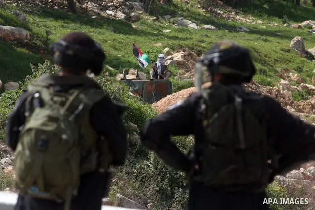 Palestinians clash with Israeli troops, not seen, during a protest outside the Ofer military prison, near the West Bank city of Ramallah Monday, March 26, 2012. Clashes erupted during a demonstration calling to release p...