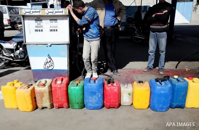 Palestinians wait to fill containers with fuel at a petrol station in Gaza City March 26, 2012. Palestinians in the Gaza Strip are suffering a crisis of dry petrol pumps and frequent blackouts triggered by a fuel supply...
