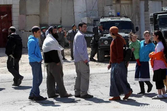 Children of Israeli settlers stand at the entrance to an occupied Palestinian house after dozens of Jewish settlers took over the property overnight, claiming they have legal ownership, in the occupied West Bank city of...