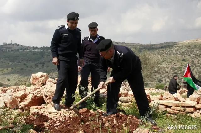 Palestinian security officers plant trees during an event marking Land Day ,in the village of Kufr Diek , West Bank, Thursday , March 29, 2011. Land Day commemorates the killing of six Arab citizens of Israel by the Isra...