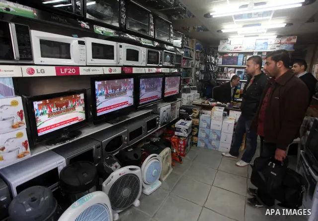 Palestinians watch TV. during a meeting of Arab foreign ministers in the framework of the Arab summit in Baghdad, Iraq, March 29, 2012. Photo by Ashraf Amra
