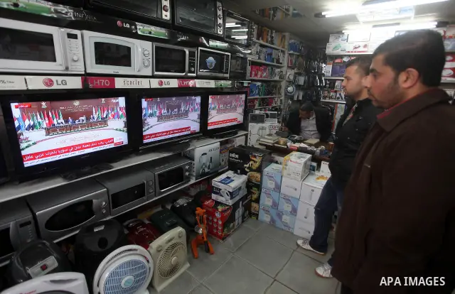 Palestinians watch TV. during a meeting of Arab foreign ministers in the framework of the Arab summit in Baghdad, Iraq, March 29, 2012. Photo by Ashraf Amra