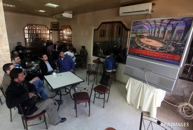 Palestinians watch TV. during a meeting of Arab foreign ministers in the framework of the Arab summit in Baghdad, Iraq, March 29, 2012. Photo by Ashraf Amra