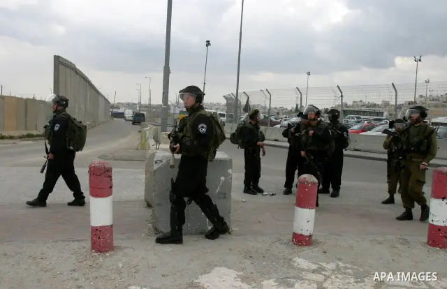 Israeli soldiers take position during clashes with Palestinian youths at the Qalandia checkpoint between the West Bank city of Ramallah and Jerusalem, on 29 March 2012. Photo by Mahfouz Abu Turk