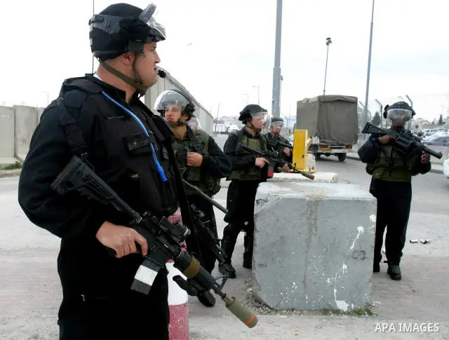 Israeli soldiers take position during clashes with Palestinian youths at the Qalandia checkpoint between the West Bank city of Ramallah and Jerusalem, on 29 March 2012. Photo by Mahfouz Abu Turk
