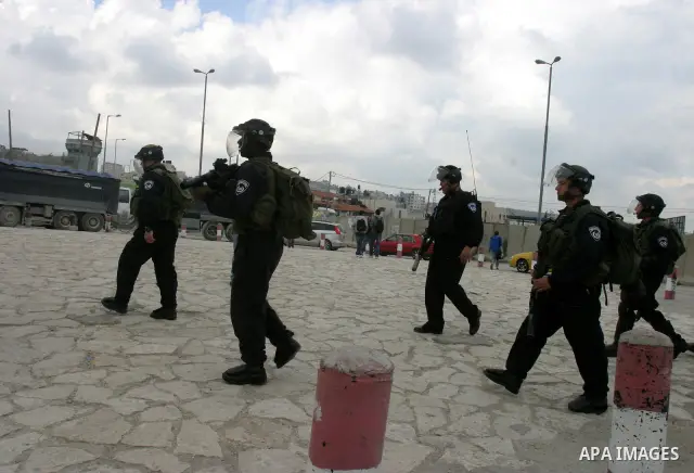 Israeli soldiers take position during clashes with Palestinian youths at the Qalandia checkpoint between the West Bank city of Ramallah and Jerusalem, on 29 March 2012. Photo by Mahfouz Abu Turk