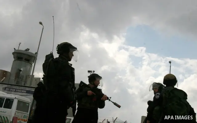 Israeli soldiers take position during clashes with Palestinian youths at the Qalandia checkpoint between the West Bank city of Ramallah and Jerusalem, on 29 March 2012. Photo by Mahfouz Abu Turk