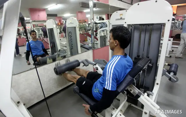 Gaza runner Bahaa al-Farra is reflected in a mirror as he trains at a gym in Gaza City March 29, 2012. The 19-year-old trains for three hours a day in Gaza's Yarmouk soccer stadium, along the dusty streets and on the bea...