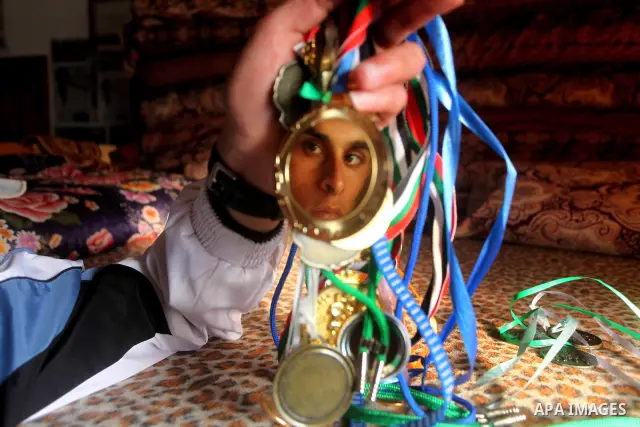 Gaza runner Bahaa al-Farra shows his medals at his house in Gaza City March 29, 2012. The 19-year-old trains for three hours a day in Gaza's Yarmouk soccer stadium, along the dusty streets and on the beach in well worn t...
